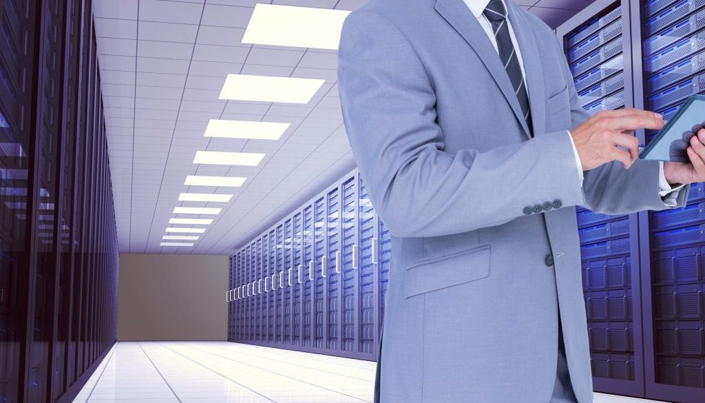 Businessman using digital tablet against server room background
