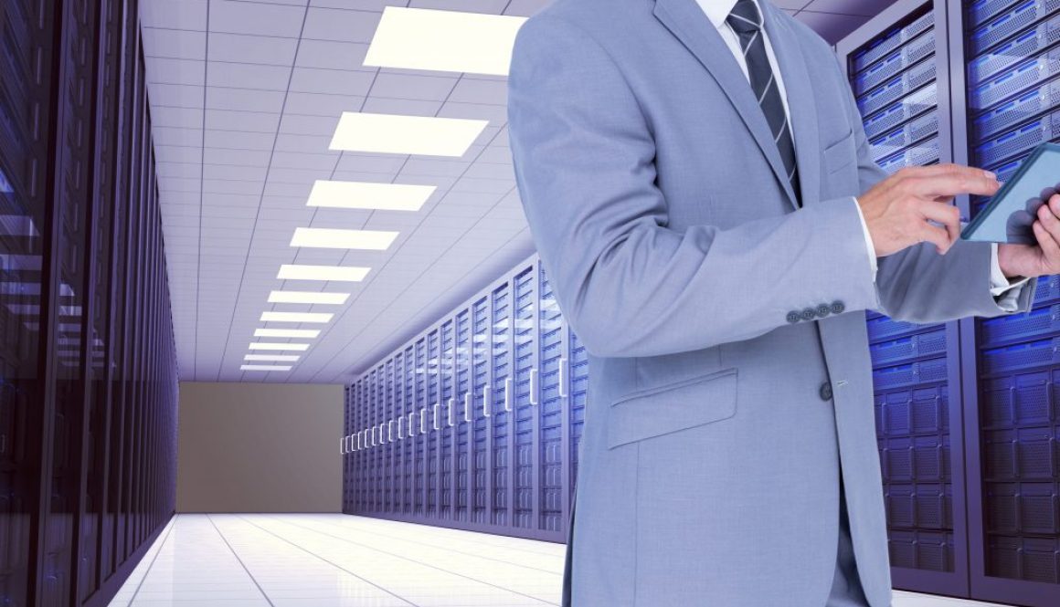 Businessman using digital tablet against server room background